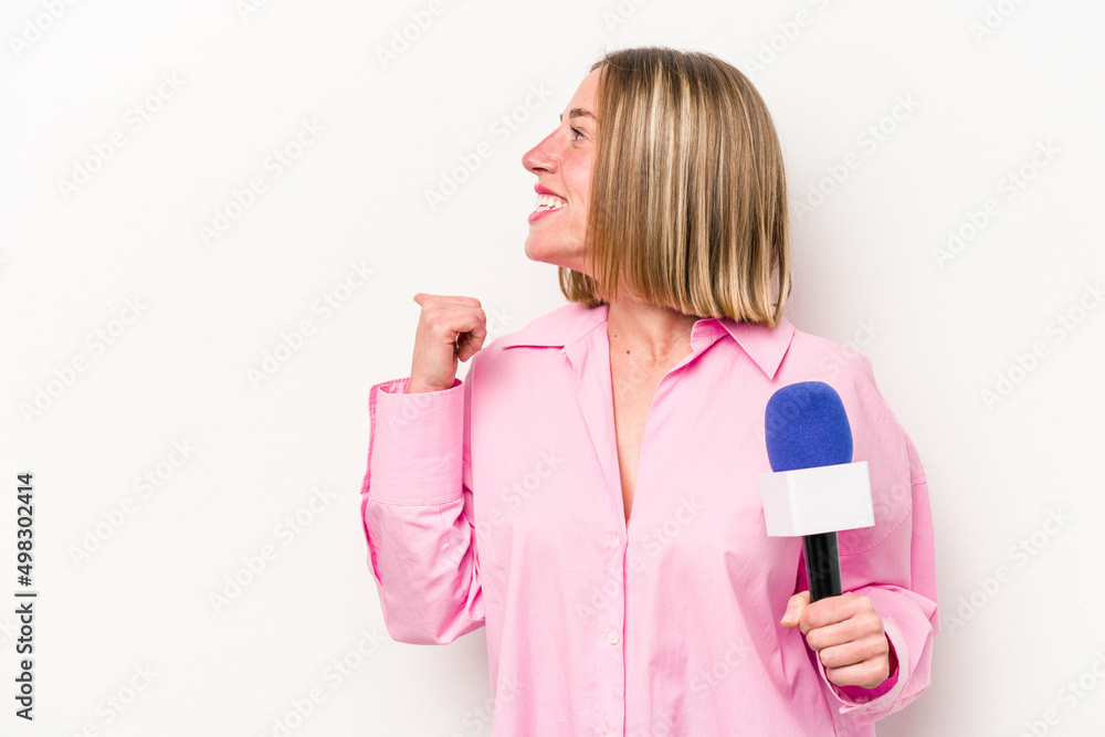 Young caucasian journalist woman isolated on white background points with thumb finger away, laughing and carefree. Young caucasian journalist woman isolated on white background points with thumb finger away, laughing and carefree.