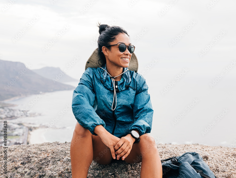 Smiling woman in sunglasses relaxing after hike enjoying the view Smiling woman in sunglasses relaxing after hike enjoying the view