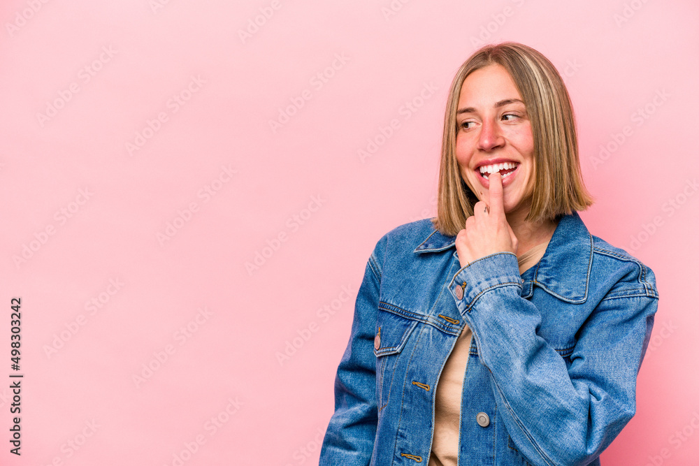 Young caucasian woman isolated on pink background relaxed thinking about something looking at a copy space. Young caucasian woman isolated on pink background relaxed thinking about something looking at a copy space.