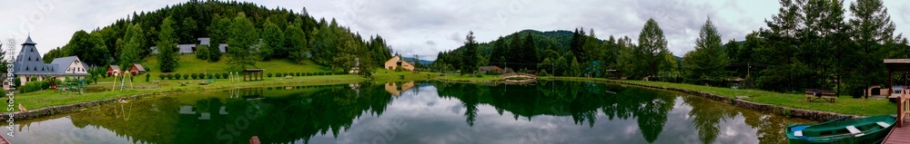Rest area in the mountains near the lake, green forest and wooden houses. Rest area in the mountains near the lake, green forest and wooden houses.
