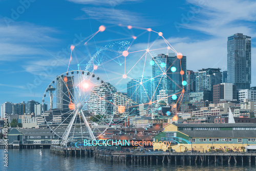 Seattle skyline with waterfront view. Skyscrapers of financial downtown at day time, Washington, USA. Decentralized economy. Blockchain, cryptography and cryptocurrency concept, hologram