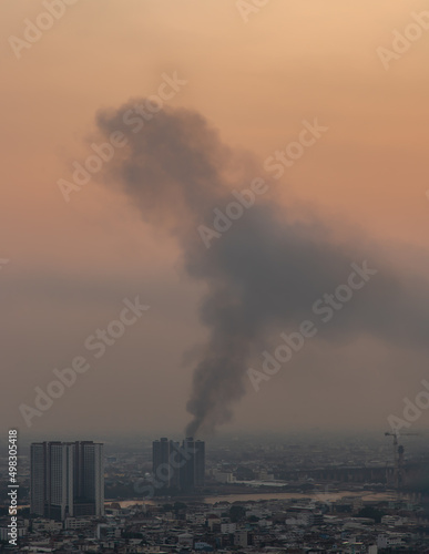 Bangkok  Thailand - 08 Apr  2022   Plume of black smoke clouds from Burnt buildings on fire at some area in the bangkok city in the evening. Fire disaster accident  Selective focus.