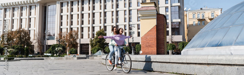 Positive woman riding bike with man on urban street, banner.