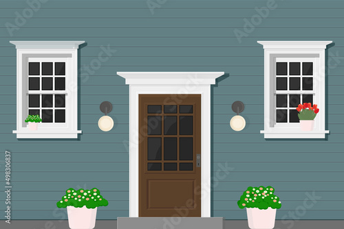 blue wooden house with white windows and white door with flowers
