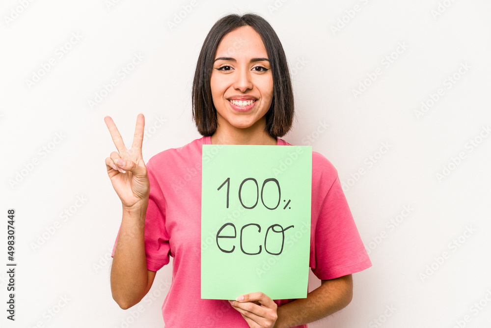 Young hispanic woman holding 100% eco placard isolated on white background showing number two with fingers.