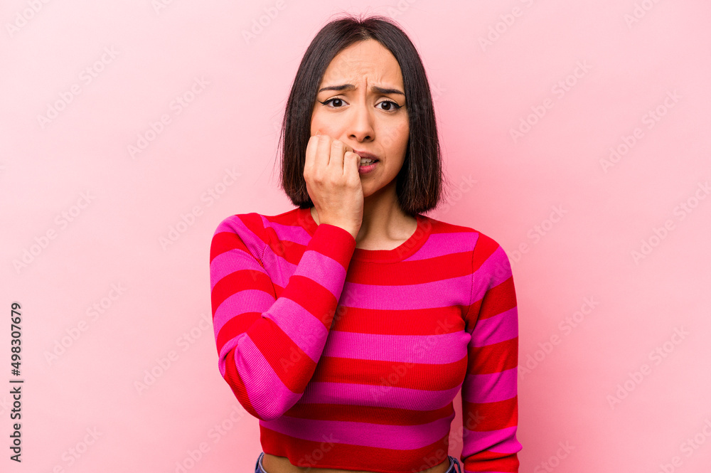Young hispanic woman isolated on pink background biting fingernails, nervous and very anxious. Young hispanic woman isolated on pink background biting fingernails, nervous and very anxious.