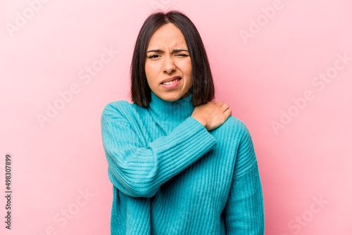 Young hispanic woman isolated on pink background having a shoulder pain. © Asier