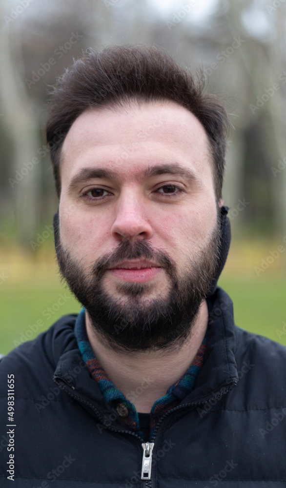 Portrait of man with earmuff. No expression on his face. Outdoor background. Close up photo. Portrait of man with earmuff. No expression on his face. Outdoor background. Close up photo.