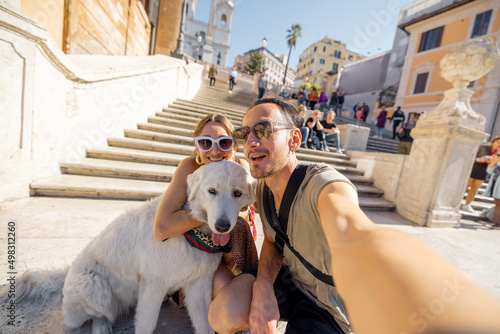 Photography Man and woman taking selfie photo with a dog on backgorund of Spanish steps