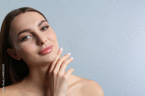 Fotografie Portrait of beautiful young woman with plump lips on light grey background