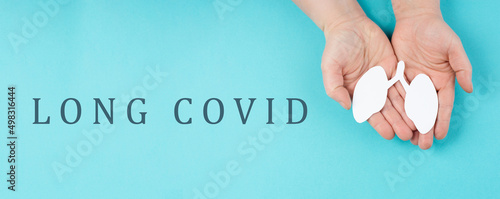 The words long covid are standing on a paper, hands hold a lung, breathing problems after Covid-19 disease
 photo