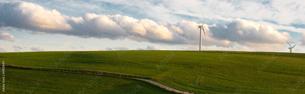 Stormy weather in the spring, clouds in the sky, green meadow, agriculture in Germany, landscape, wind energy and environment discussion, countryside scene