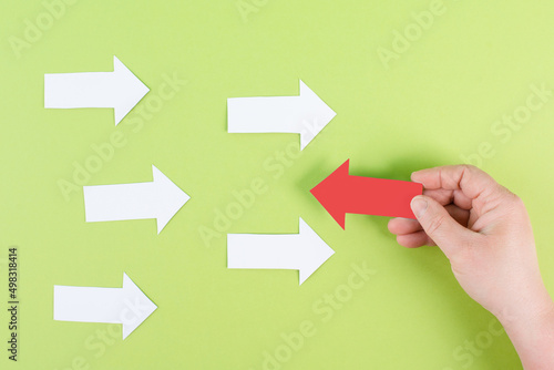 White arrows on a green background, one is standing out, do different, be a winner, individuality, making your own decision, leadership, target new idea  photo