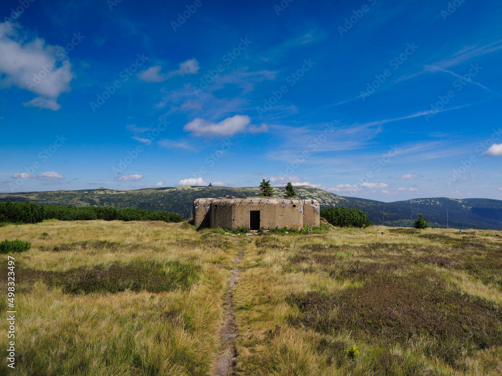 On a hill is old second war bunker under blue sky with clouds. CZ. Krkonose.