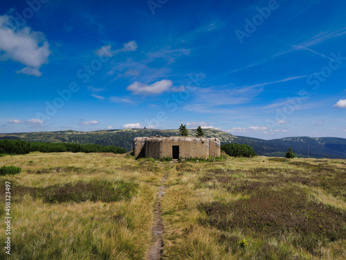 On a hill is old second war bunker under blue sky with clouds. CZ. Krkonose.