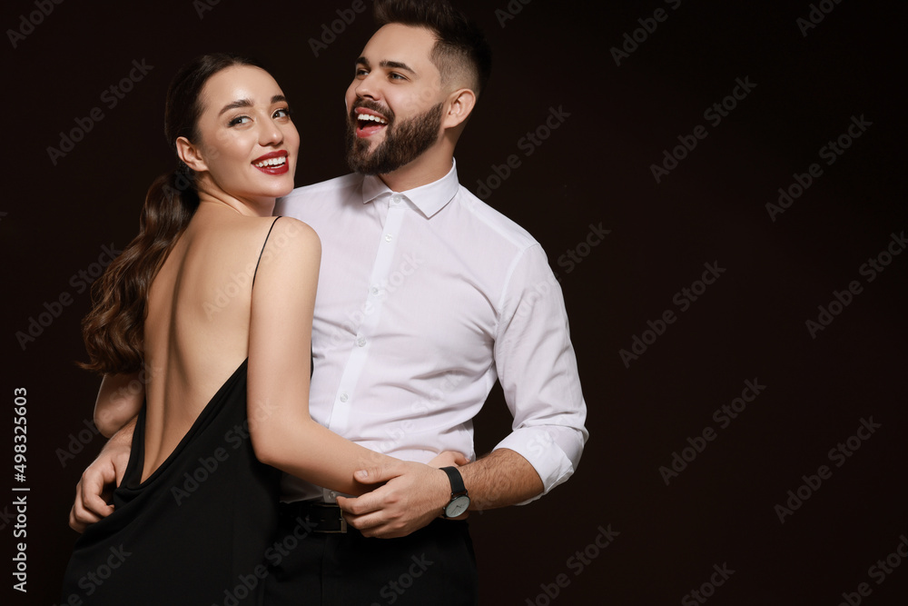 Handsome bearded man with sexy lady on dark background. Space for text Handsome bearded man with sexy lady on dark background. Space for text
