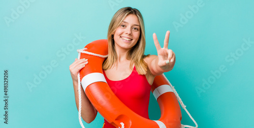 Konstfotografi pretty blonde woman smiling and looking friendly, showing number two