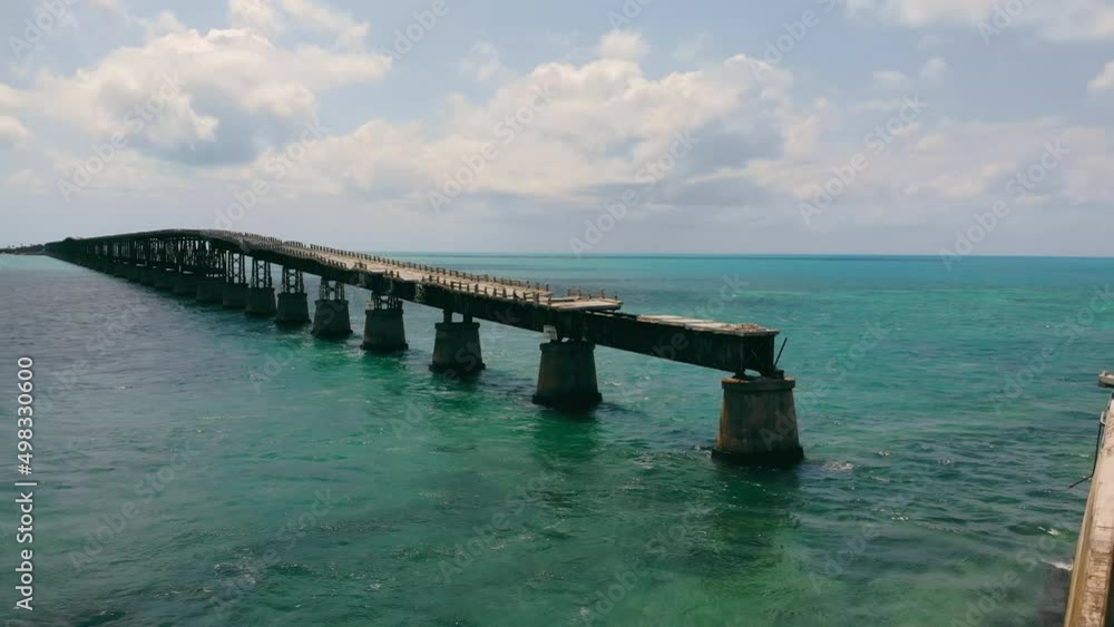 Broken bridge running over ocean surface in Florida Keys, USA. Aerial view from drone of old Bahia bridge along ocean with scenic horizontal oceanscape, with copy space. Concept of architecture Broken bridge running over ocean surface in Florida Keys, USA. Aerial view from drone of old Bahia bridge along ocean with scenic horizontal oceanscape, with copy space. Concept of architecture