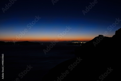Panoramic view of the illuminated village of Fira, Oia and a spectacular sunset in Santorini
