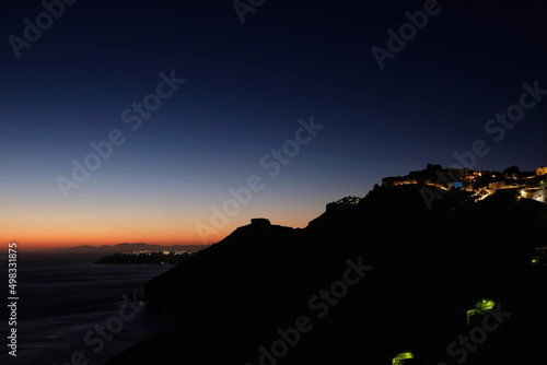 Panoramic view of the illuminated village of Fira, Oia and a spectacular sunset in Santorini