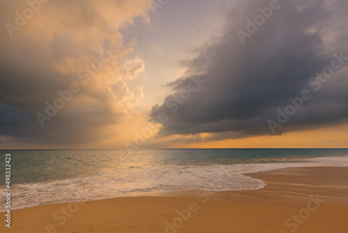 Foamy waves on the sandy ocean beach under a beautiful sunset sky with clouds on Sri Lanka island.