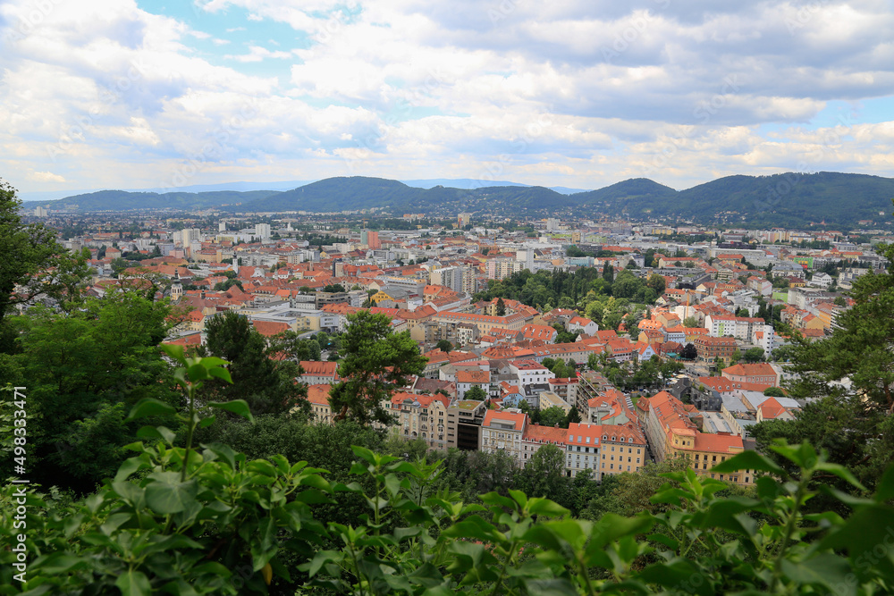 Panoramic view from the Castle Montain to the city of Graz, Austria with the Graz hills in the background at cloudy sky