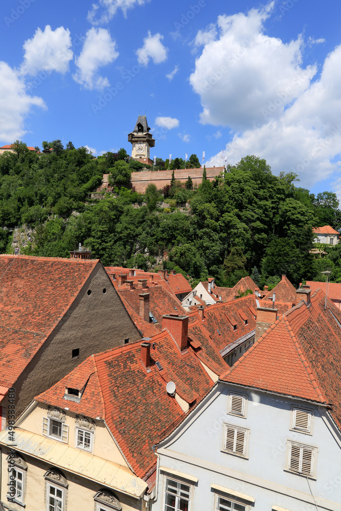 View over the roofs of the city of Graz, Austria to the famous clock tower at the castle mountain