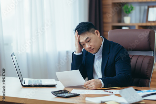 Young asian male accountant, office worker working with documents, tired, sittin Fototapet