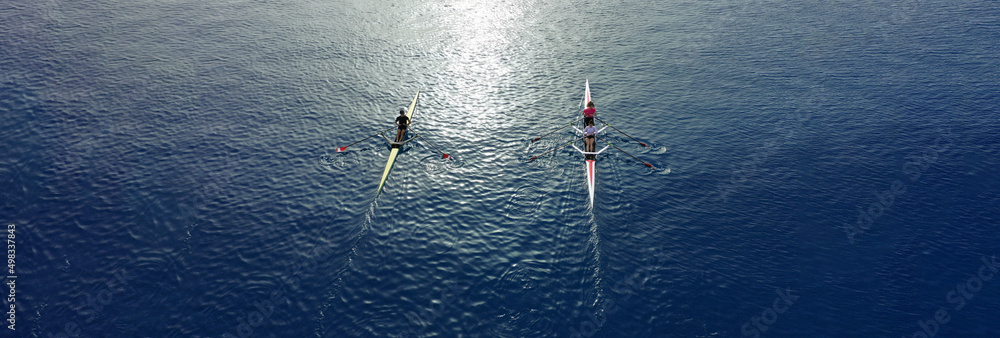 Aerial drone ultra wide top down panoramic photo with copy space of sport canoe operated by young woman in deep blue calm sea waters