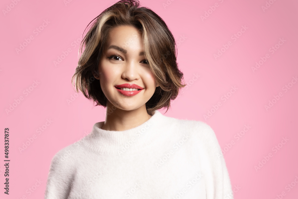 Friendly happy modern girl with stylish short hairs, perfect spring makeup posing on bright pink studio background, advertising skincare and make up cosmetics for youth skin. Friendly happy modern girl with stylish short hairs, perfect spring makeup posing on bright pink studio background, advertising skincare and make up cosmetics for youth skin.