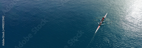 Aerial drone ultra wide top down panoramic photo with copy space of sport canoe operated by young woman in deep blue calm sea waters © aerial-drone