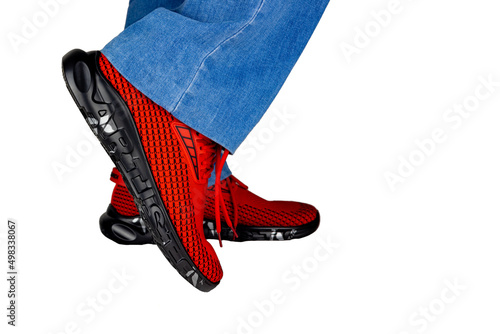 Regular Fit Straight Leg Jeans and red sports Sneakers isolated on white background, selective focus (detailed close-up shot)