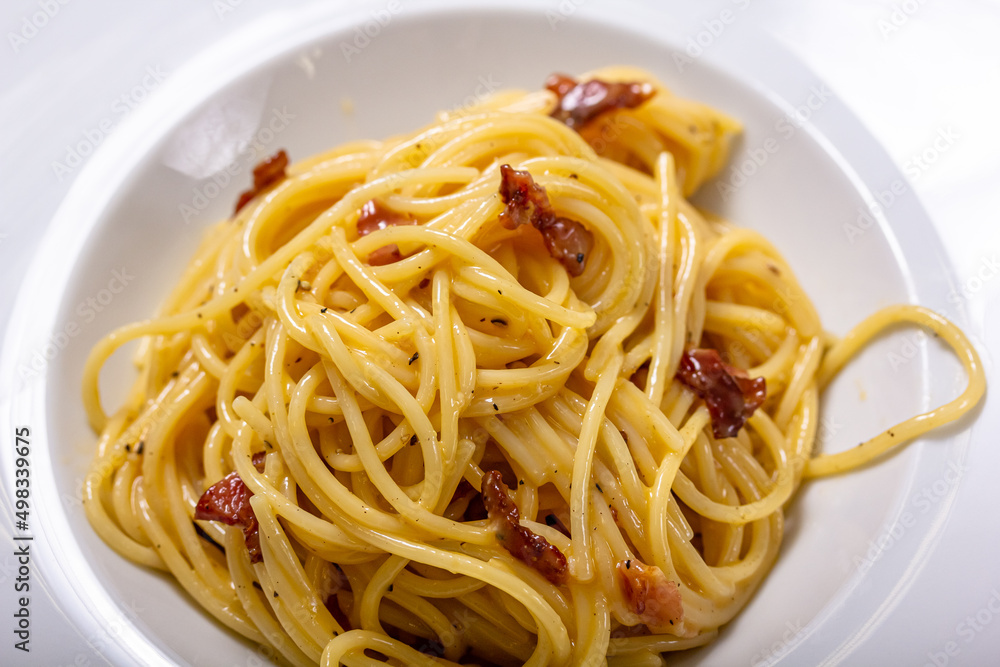Italian delicious spaghetti carbonara pasta with bacon parmesan lies in a plate