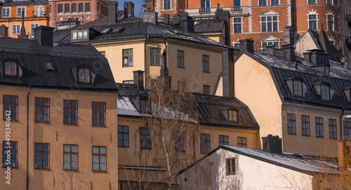Dorms, chimneys and towers with black tin roofs on old 1700s buildings a snowy spring day in Stockholm