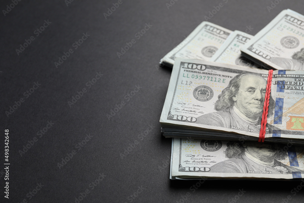 Many dollar banknotes on black background, closeup. Space for text Many dollar banknotes on black background, closeup. Space for text