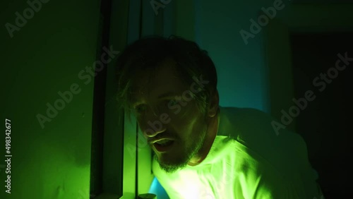 A mad male patient in straitjacket is going crazy in a mental hospital. Close up of mentally ill man with psychic disorders and bipolar disease. Concept of paranoia or schizophrenia and madness.