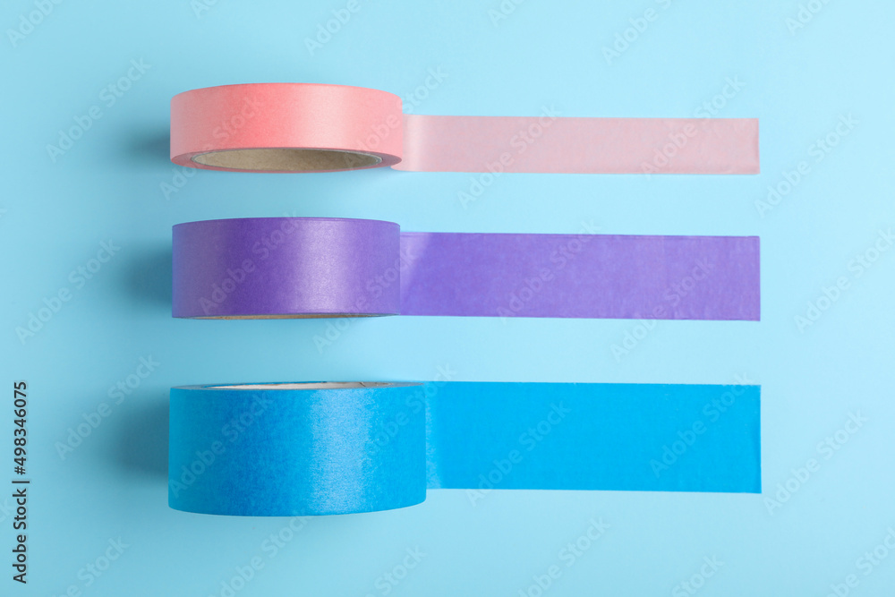 Many rolls of adhesive tape on light blue background, flat lay Many rolls of adhesive tape on light blue background, flat lay