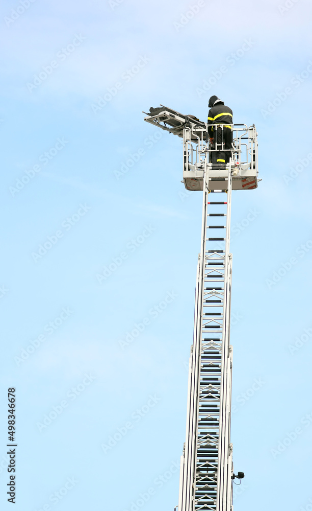 fireman on the basket of the ladder truck during the rescue of an injured person fireman on the basket of the ladder truck during the rescue of an injured person