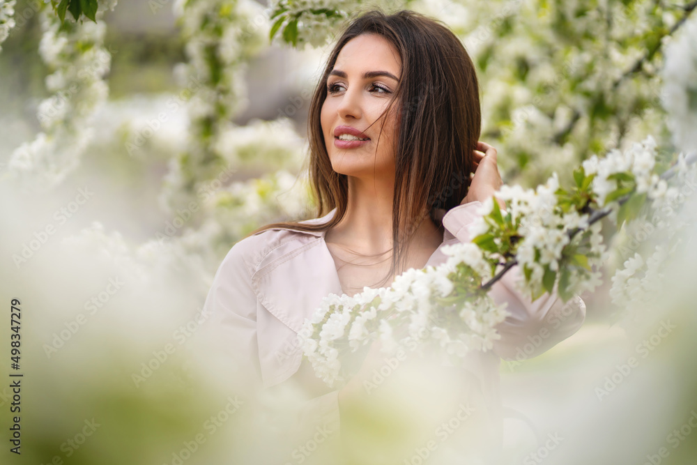 Happy smiling young woman with spring flowers in the garden Happy smiling young woman with spring flowers in the garden