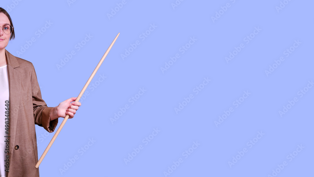 Smiling woman teacher pointing to the side on studio blue background, banner copy space Smiling woman teacher pointing to the side on studio blue background, banner copy space