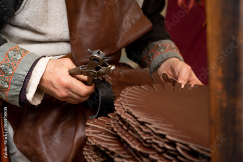 leather craftsman working in medieval market stall