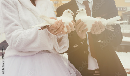 A pair of white doves in their hands