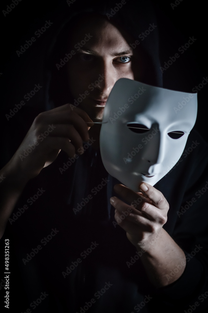 Take off the mask - Portrait of a young hooded man who takes off his mask,  letting his gaze be seen, concept for being true and authentic Stock Photo  | Adobe Stock