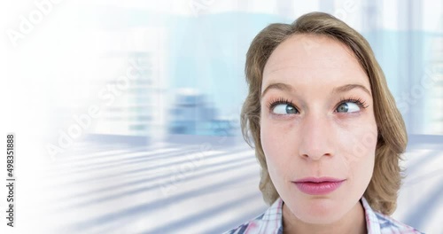 Video of crossed eyed caucasian woman over out of focus city in background photo