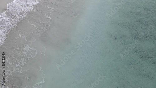 Sea waves coming to sandy beach, view from above