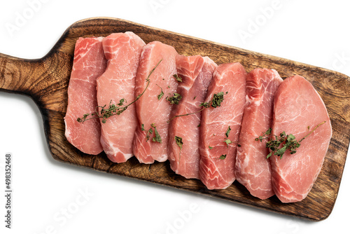 Raw pork sliced meat on wooden board on white background with dry basil leaves and spice. fresh raw beef lamb isolated on white. Heap of raw steaks