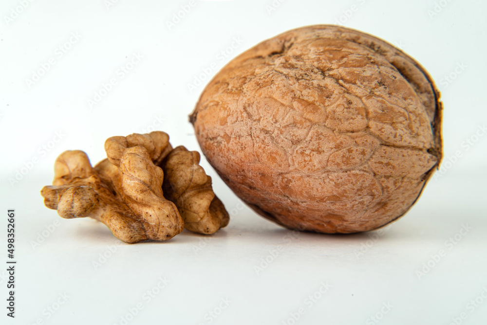 Walnut with . Walnuts peeled and unpeeled with leaves isolated on white background . Walnut nut side view. With clipping path.