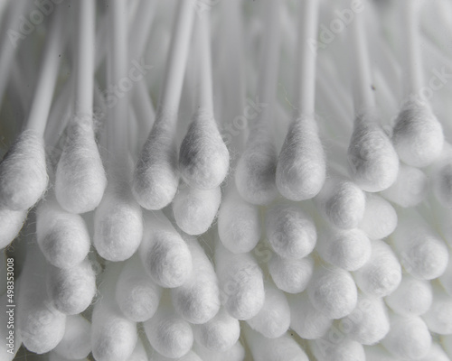 White cotton swab or cotton buds isolated on grey background. on a white plastic base for the ears  diagonal
