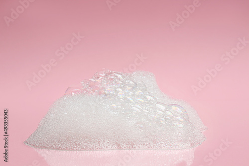 Drop of fluffy bath foam on pink background