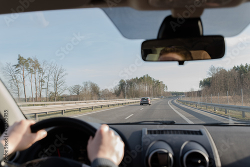 Generic photo of man driving a car through slight turn. © Dmytrii